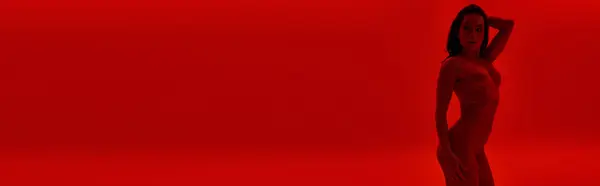 A stunning statue of a woman standing gracefully in front of a vibrant red background. — Stock Photo