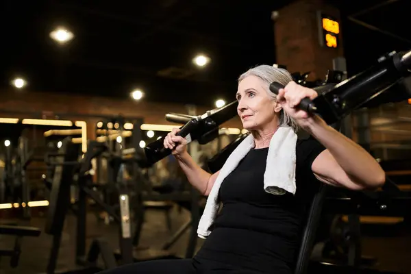 Atletica attraente donna anziana in abbigliamento sportivo che esercita sulla pressa toracica mentre in palestra — Foto stock
