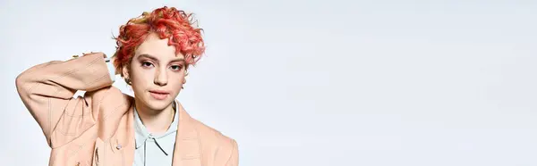 Femme extraordinaire aux cheveux roux se distingue dans une veste rose. — Photo de stock