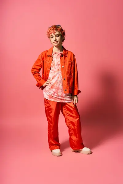 Женщина в привлекательном оранжевом пиджаке и смелых красных штанах выделяется в его красочном наряде.. — стоковое фото