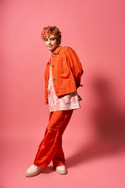 Stylish woman wearing an orange jacket and red pants. — Stock Photo