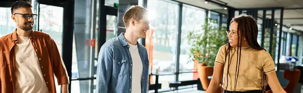 Multicultural colleagues in casual attire walking together along a hallway during a corporate trip. — Stock Photo