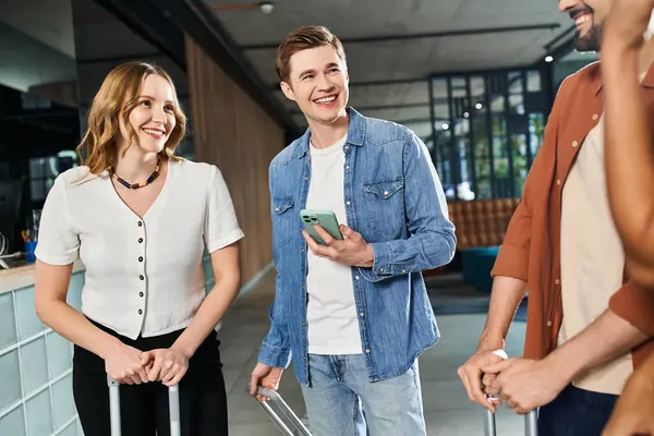 Multicultural colleagues in casual attire standing together in a hotel lobby during a corporate trip. — Stock Photo