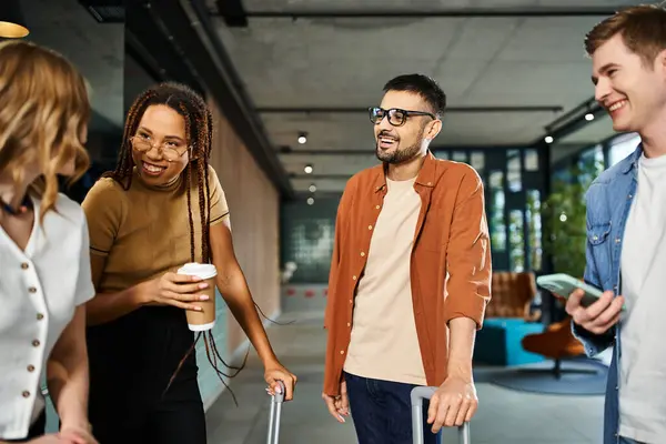 Multicultural colleagues in casual attire stand in a circle in a hotel lobby during a corporate trip, engaged in conversation. — Stock Photo