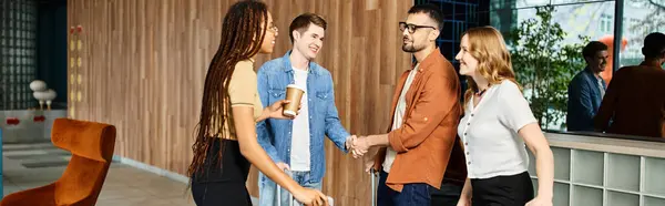 Multicultural colleagues in casual attire standing together in a hotel lobby during a corporate trip. — Stock Photo