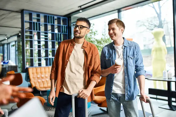 Colleagues in casual attire stand together in a hotel lobby, engaged in conversation. — Stock Photo