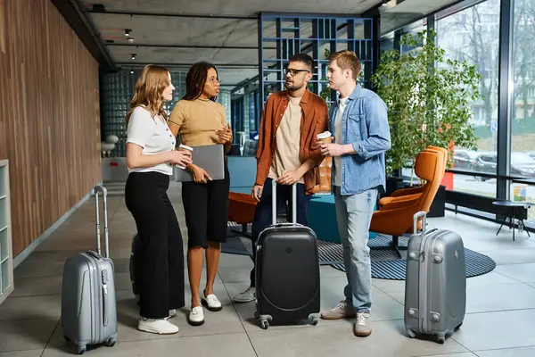 Multicultural group of businesspeople in casual attire standing around with luggage in a hotel lobby during a corporate trip. — Stock Photo