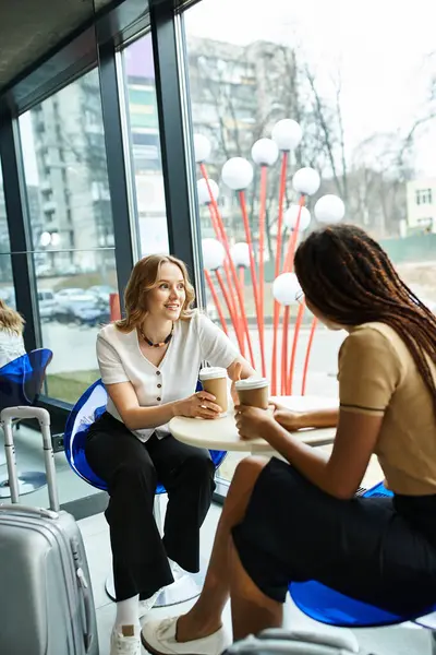 Colegas multiculturales participan en animadas discusiones alrededor de una mesa durante un viaje corporativo. - foto de stock