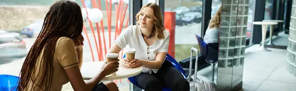 Colegas multiculturales absortos en la conversación en un entorno hotelero durante un viaje corporativo. - foto de stock