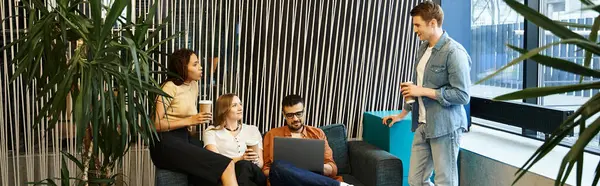 A group of colleagues working together on couches in a modern office setting, discussing ideas and projects. — Stock Photo
