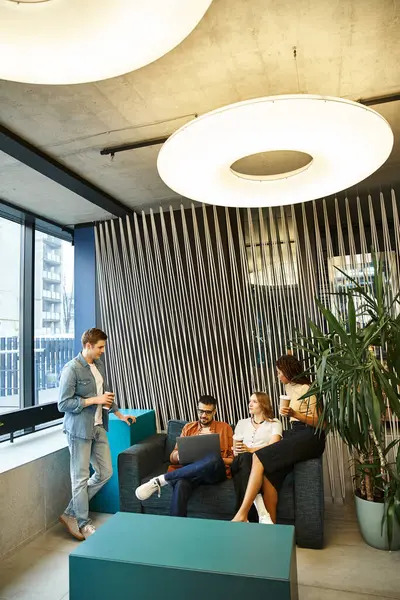 Un groupe diversifié de collègues dans un espace de coworking moderne, assis et engagés dans une séance de remue-méninges. — Photo de stock