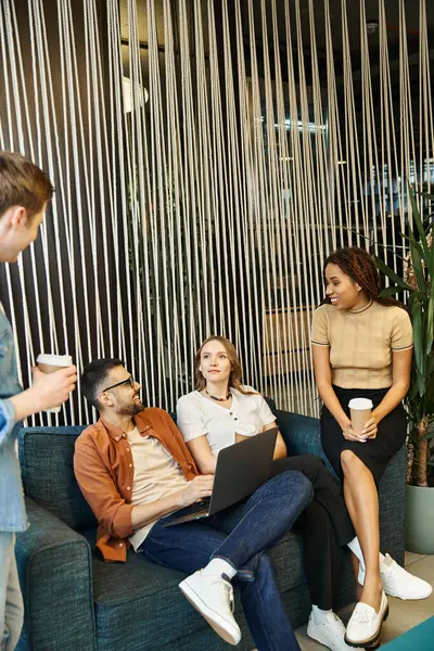 Une équipe créative de collègues en démarrage partage des idées innovantes lorsqu'ils sont perchés sur un canapé dans un espace de coworking moderne. — Photo de stock