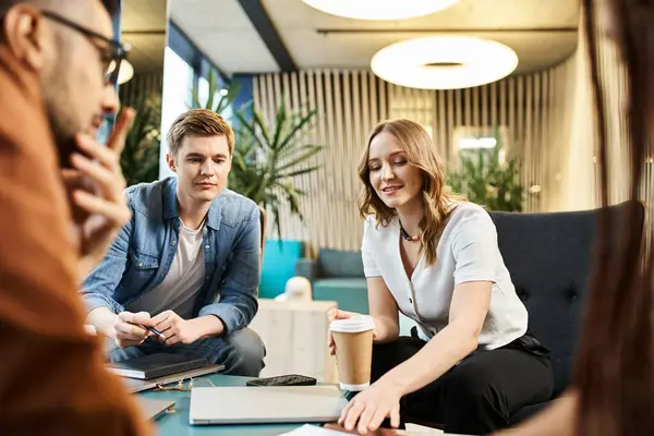 Un groupe de collègues dans un espace de coworking moderne, engagés dans la collaboration et la discussion autour d'une table. — Photo de stock