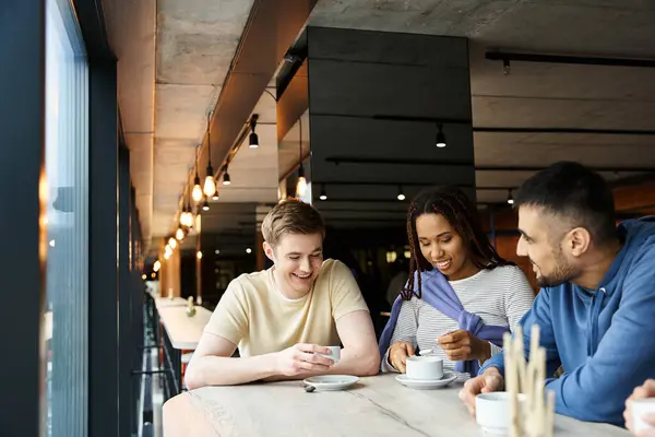 Un grupo diverso de colegas de un equipo de startups disfrutando de un café juntos alrededor de una mesa en un espacio de coworking. — Stock Photo