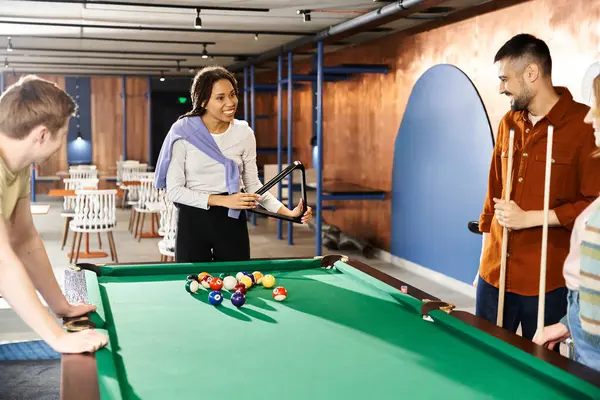Un gruppo di colleghi di un team di startup che si godono una partita a biliardo in un ambiente moderno. — Foto stock