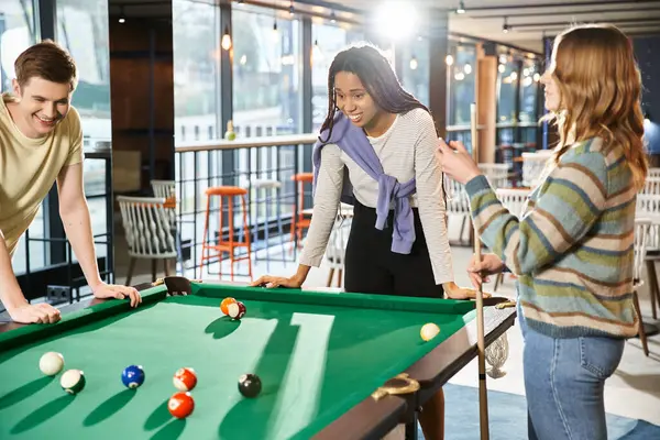 Colleagues from a coworking space challenge their startup team members to a game of pool during a break. — Stock Photo