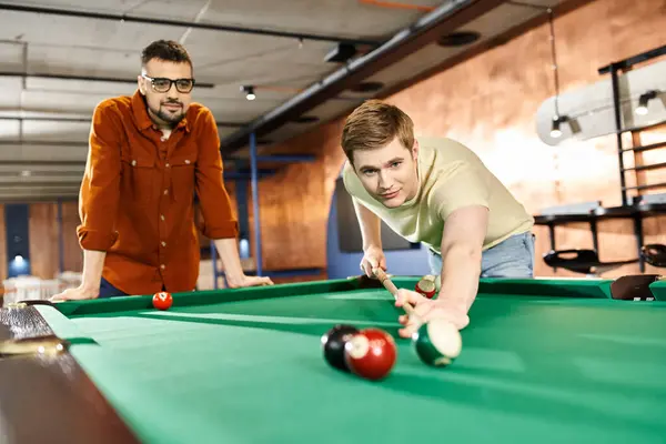 Men strategize and compete in a game of pool, showcasing teamwork and friendly competition in a coworking space. — Stock Photo