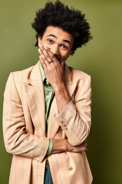 Handsome African American man in a stylish suit, deep in contemplation with hands over his mouth. — Stock Photo