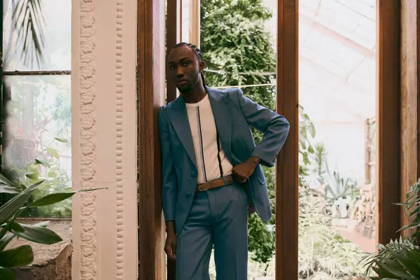 A dapper African American man in a blue suit stands confidently within a room. — Stock Photo