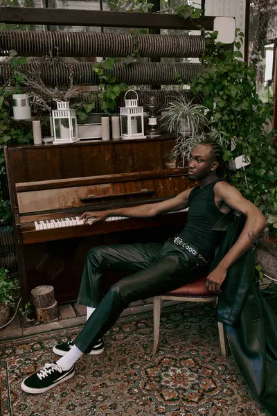 Un uomo con stile elegante siede accanto a un pianoforte in un vivido giardino verde. — Foto stock