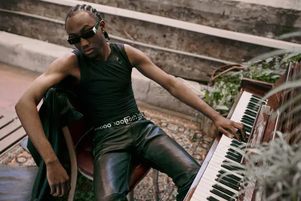 A dapper African American man sits on a bench next to a piano in a vibrant green garden. — Stock Photo