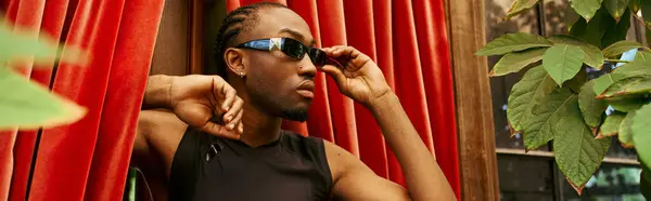 A stylish African American man in a black shirt and sunglasses. — Stock Photo