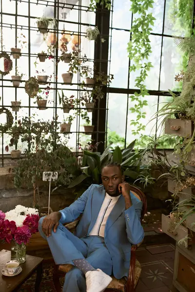A handsome African American man with sophisticated style in a vivid green garden. — Stock Photo