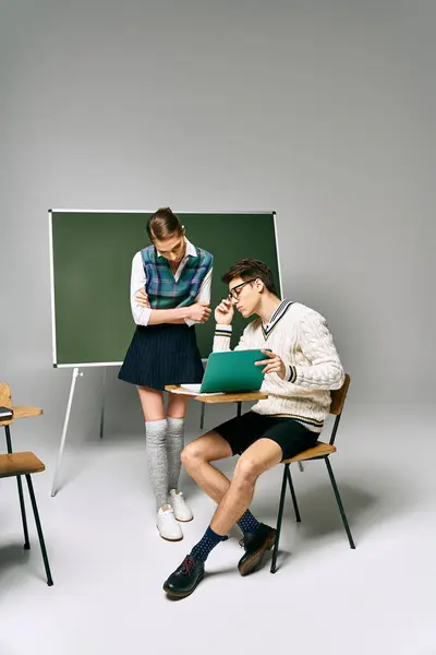 Чоловік і жінка сидять перед зеленою дошкою в коледжі. — Stock Photo