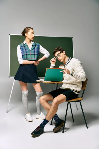 Estudantes masculinos e femininos elegantes sentam-se em frente a um quadro verde na faculdade. — Fotografia de Stock