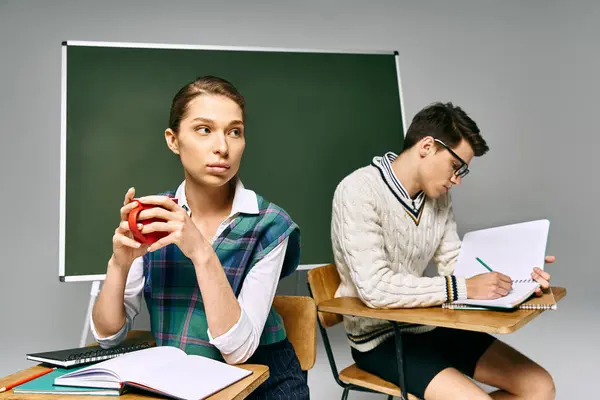 Elegant man and woman sitting by green board. — Stock Photo