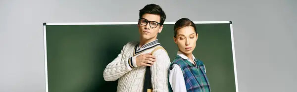 Bello uomo e bella donna in posa accanto a bordo verde al college. — Foto stock