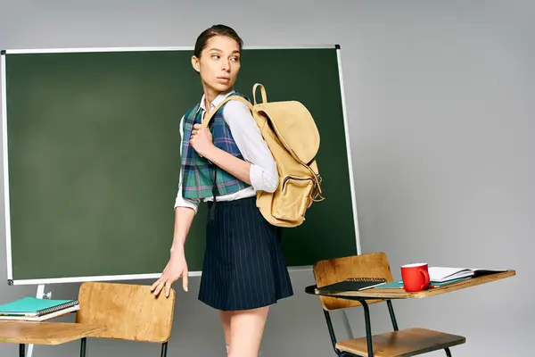 Uniforme donna con zaino stand di bordo verde al college. — Foto stock