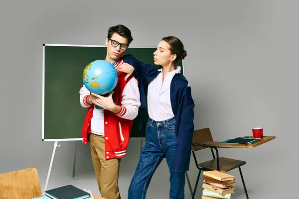 Ein Student und eine Studentin stehen vor einem Hörsaal und studieren einen Globus. — Stockfoto