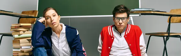 Two young students seated by a green board. — Stock Photo