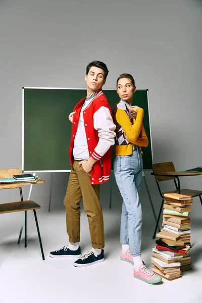 Dois estudantes universitários elegantes posar na frente de uma placa verde, exalando confiança e intelecto. — Fotografia de Stock