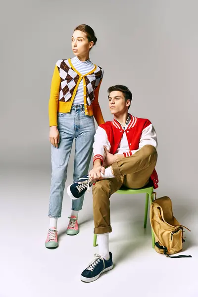 Attractive students pose on a chair in a college classroom. — Stock Photo