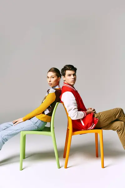 Stylish students lounge on a colorful chair in a college classroom. — Stock Photo