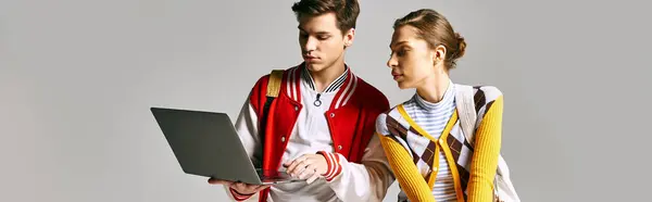 Young male and female students engrossed in laptop in college classroom. — Stock Photo