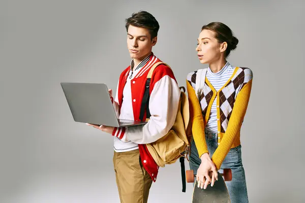 Young male and female students standing together with a laptop in a college classroom. — Stock Photo