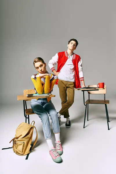 Attractive male and female students posing casually in a college classroom. — Stock Photo