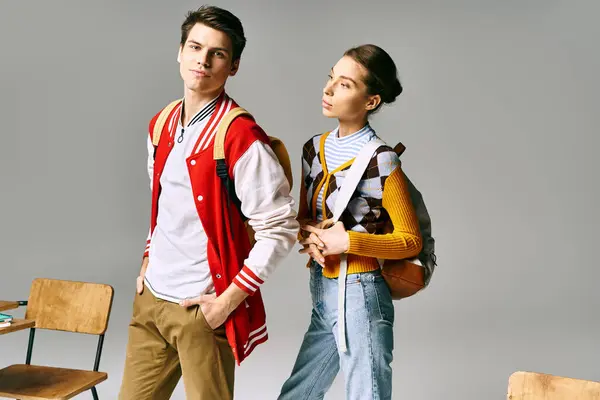 A male and female students standing coyly together in a college classroom. — Stock Photo