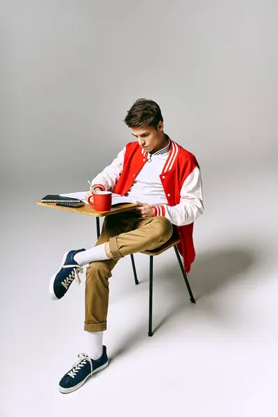 Um homem de casaco vermelho relaxa em uma cadeira com uma xícara de café. — Fotografia de Stock