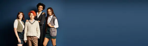 Young multicultural friends, including a nonbinary person, standing together in stylish attire on a dark blue background. — Stock Photo