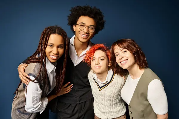 Young multicultural friends, including a nonbinary person, stand together in stylish attire against a dark blue background. — Stock Photo
