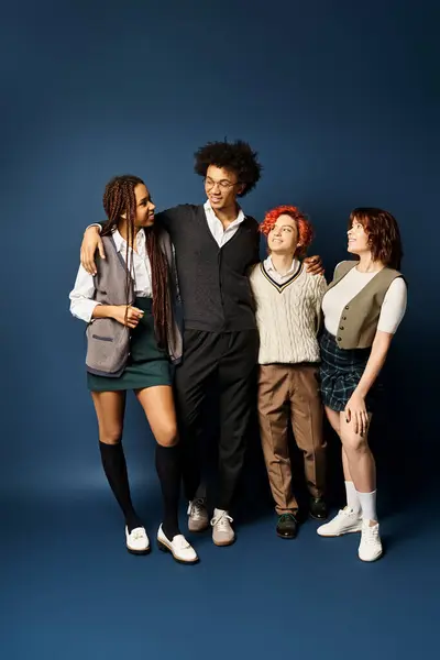 A diverse group of young friends, stand together in stylish attire against a dark blue background. — Stock Photo