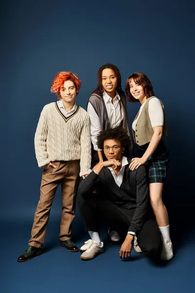 Multicultural friends, stand together in stylish attire on a dark blue background, posing for a picture. — Stock Photo