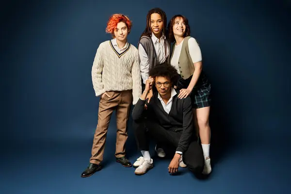 Um grupo de jovens amigos multiculturais, ficar ao lado uns dos outros em trajes elegantes em um fundo azul escuro. — Fotografia de Stock