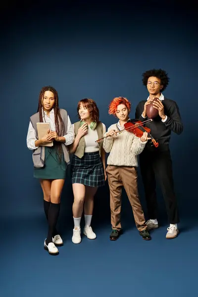 A group of young multicultural friends, stand together in stylish attire against a dark blue background. — Stock Photo