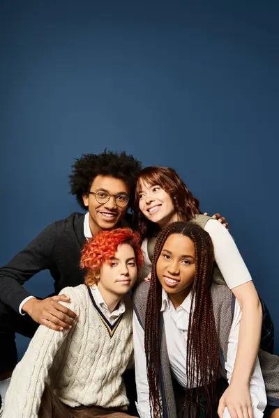Amici multiculturali colpiscono una posa in abiti alla moda su uno sfondo blu scuro. — Foto stock
