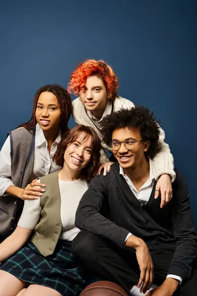 A group of young friends, sitting together in stylish attire on a dark blue background. — Stock Photo